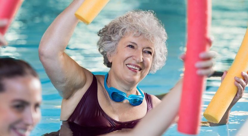 lächelnde Frau im Wasser bei Aqua Fitness